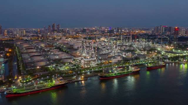 Hyperlapse aerial view of industrial park with oil refinery at twilight